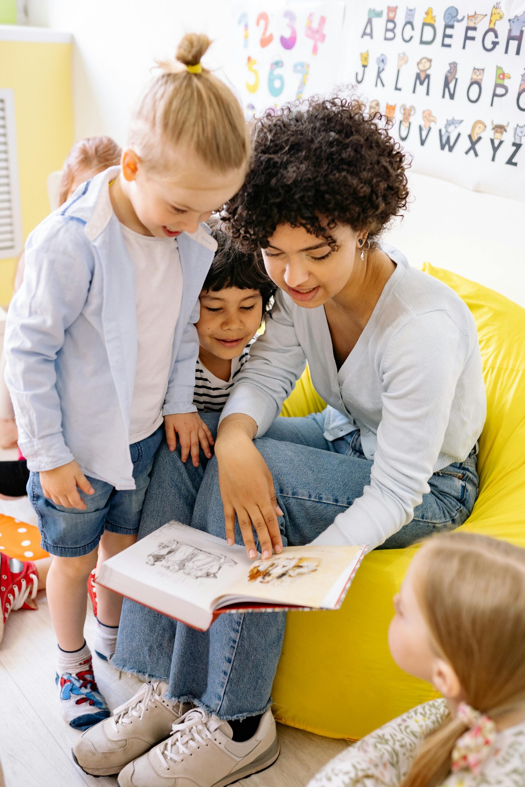 Therapist reads a story to a small group of happy and engaged children